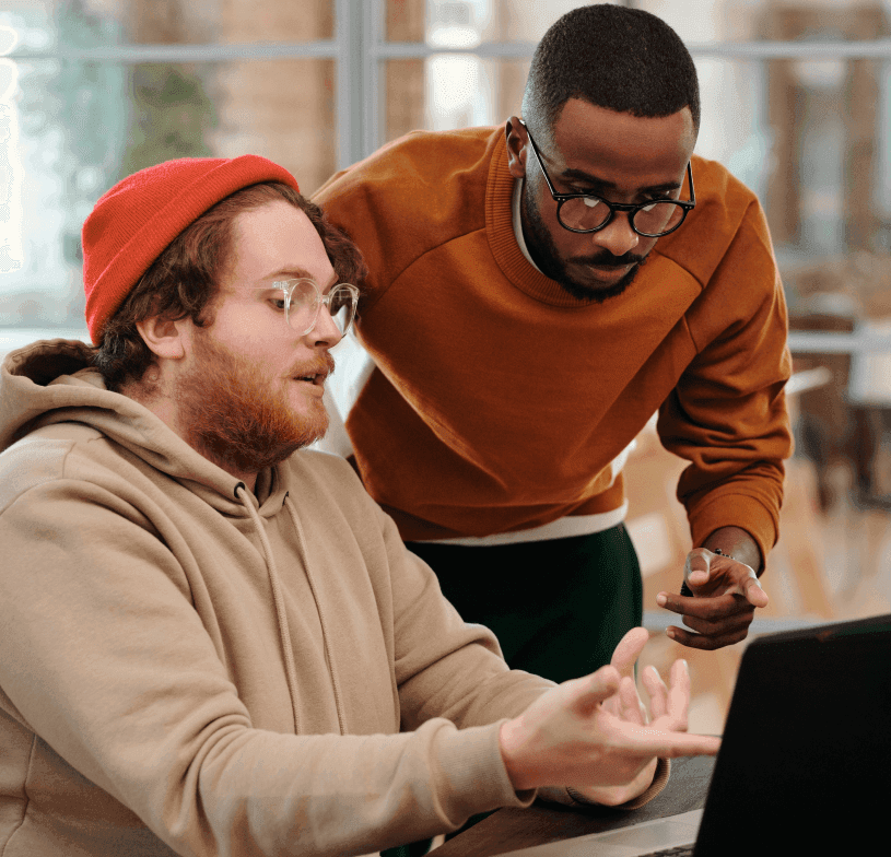 Two colleagues reviewing work on a laptop